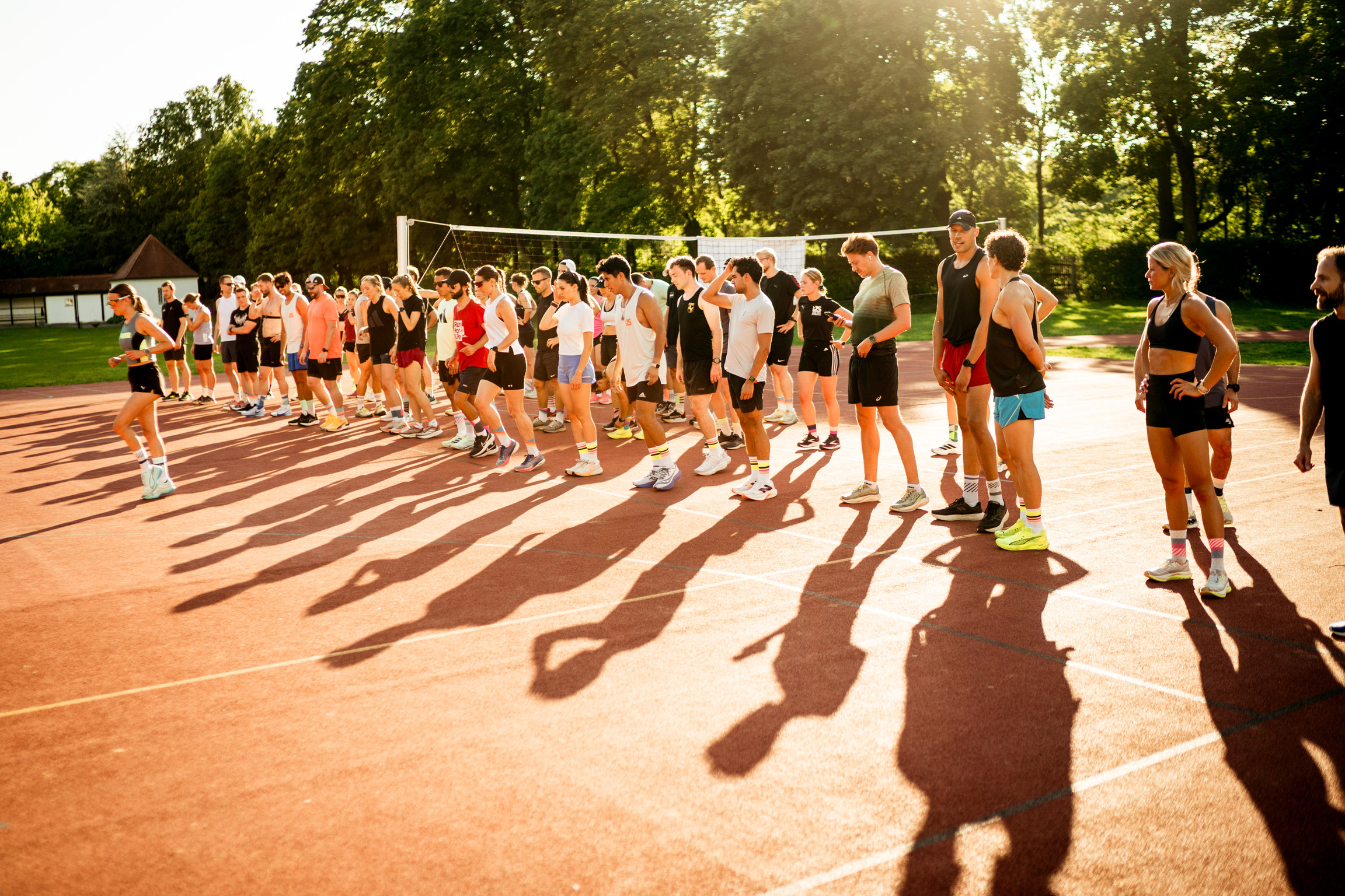 runningsociety Gruppe auf der Tartanbahn, goldene Stunde